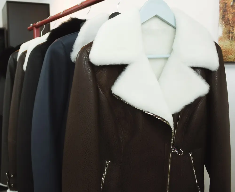 A rack of leather jackets with fur collars.
